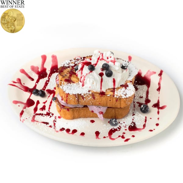 TRUreligion's blueberry stuffed French toast, topped with whipped cream, berry syrup, and powdered sugar.