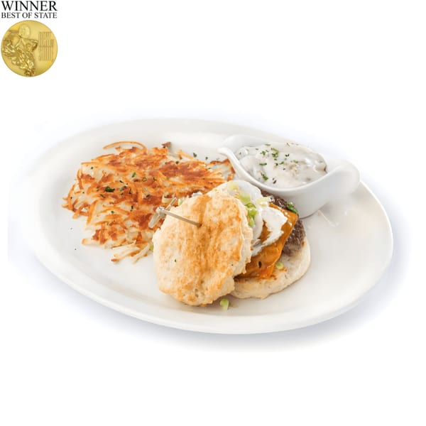 TRUreligion breakfast plate with a biscuit sandwich, hash browns, and a side of gravy.